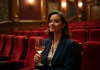 Théâtre : pourquoi ne pas siroter un verre pendant le spectacle ? Femme élégante dans un théâtre avec verre de vin